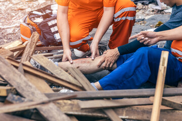 paramedic medical emergency team working help labor accident at dirty construction site leg injury...