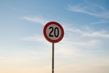 20 miles km maximum speed limit traffic sign isolated with sunset sky