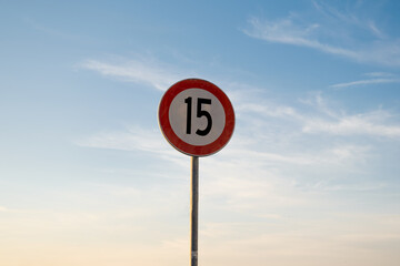15 miles km maximum speed limit traffic sign isolated with sunset sky