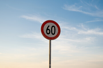 60 miles km maximum speed limit traffic sign isolated with sunset sky