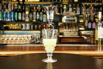 Classic type of absinthe preparation with brouiller (a tool for preparing absinthe). Glass with...