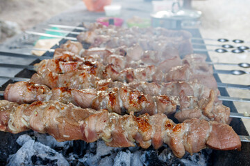 Meat skewers preparation on charcoal barbecue grill with smoke