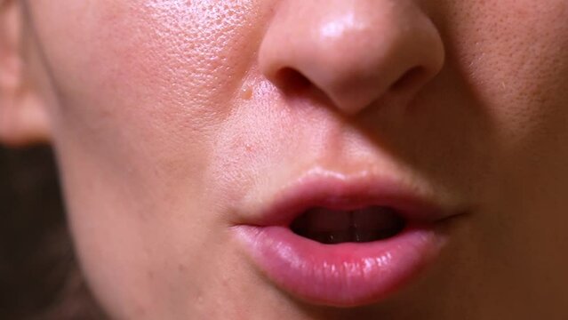 Close-up of female mouth talking to camera in Vox pop style moving lips, Lower face of female speaker with beautiful teeth leading conversation while delivering monologue