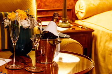Champagne bottle in an ice bucket with two champagne glasses