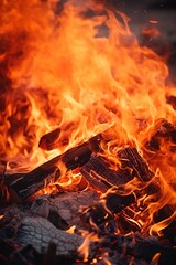 Fototapeta premium Vivid close-up of a blazing fire with dynamic flames, ideal for themes related to energy, warmth, cooking, or outdoor activities. Vertical background with fire.