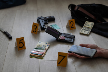 Hand of dead victim surrounded by evidence markers and objects on floor of residential apartment. Crime scene investigation and documentation process - Powered by Adobe