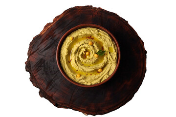 Hummus in a brown ceramic bowl on a wooden board. A vegetarian meal. Top view. On a transparent background