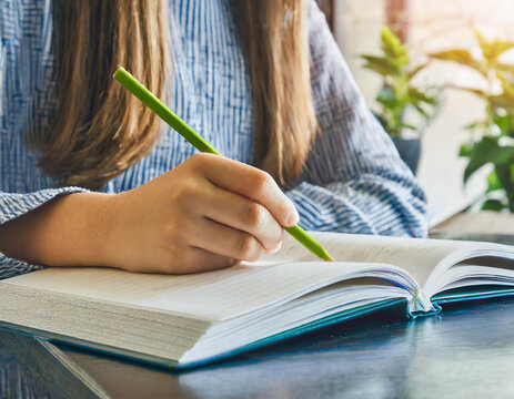 Closeup of girl writing on her journal