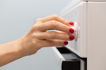 Naklejka premium a woman's hand rotates the selector on a gas stove
