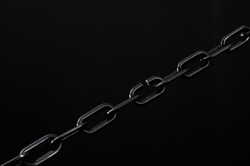 Black plastic chain on black background