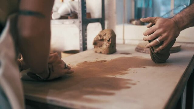 Hands, clay and artists creating in a workshop for ceramic products for small business startup. Creativity, art and closeup of male sculptors working with mud for pottery manufacturing skills in shop