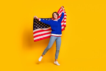 Full length photo of lovely cheerful lady dressed knitted sweater rising american flag isolated...