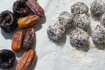 Healthy vegan sweets made from dates and prunes, cocoa and nuts in coconut flakes. Raw vegetarian...