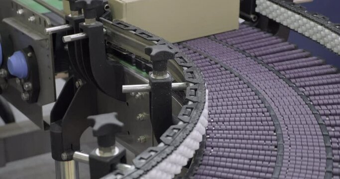 Cardboard box moving on the conveyor belt, real time handheld shot, warehouse interior