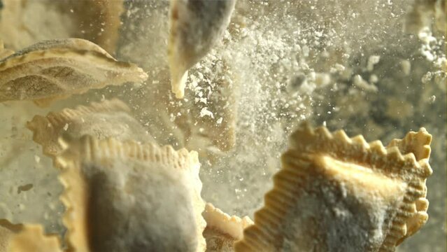 Italian ravioli fly up and fall down with flour. Filmed on a high-speed camera at 1000 fps. High quality FullHD footage