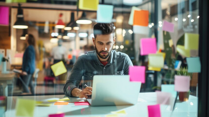 Fototapeta premium Focused Professional Working on Laptop Surrounded by Sticky Notes