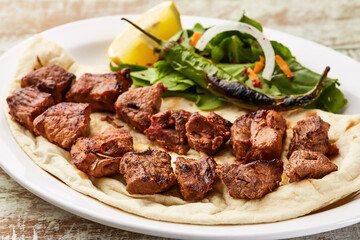 Beef tikka boti kababa with lime slice and salad served in dish isolated on table top view of arabic food
