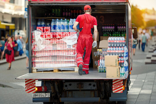 Minsk, Belarus. Jul 5, 2023. Coca Cola delivery man unloading truck, delivery of food and drinks to restaurants, cafes, shops. Lorry full of boxes of Coca-cola beverages. Coca Cola delivering drinks