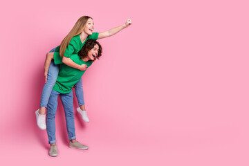 Full size profile side photo of couple teenagers playing together girl ride piggyback fist up to...