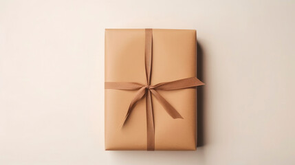 Gift wrapped in brown paper and tied with twine on light beige background, minimalism, retro style. Gift for holiday or celebration: birthday, Valentine's day, wedding. Top view. Copy space.