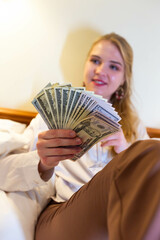 Dynamic female business worker's hands counting dollar banknotes at the vintage hotel room