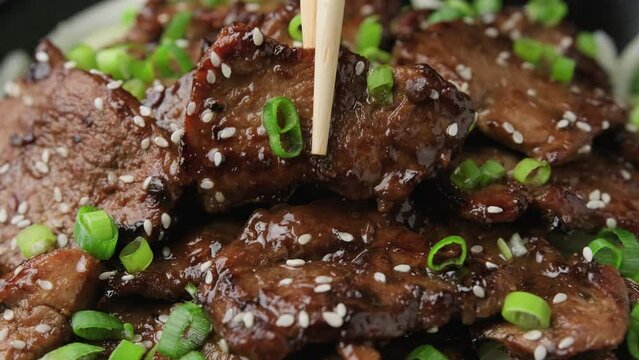 Eating Korean BBQ Maekjeok, Doenjang Marinated Pork with chopstick