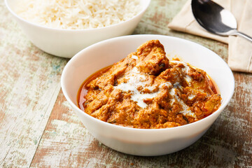 Spicy Butter Chicken makhani masala korma karahi with boiled rice served in dish isolated on table top view of arabic food
