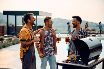 Cheerful man drink beer and talk while making barbecue by poolside.