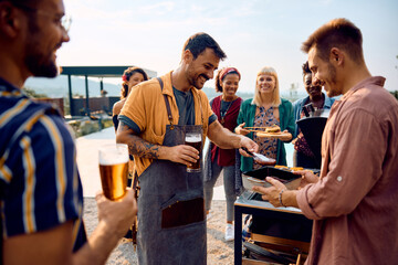 Group of happy friends enjoy on barbecue party during summer day.