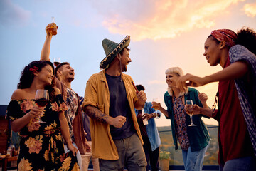 Cheerful friends dancing and having fun while having party on patio. - Powered by Adobe