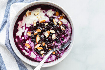 Yogurt berry bowl topped with almond pieces, ready for eating. 