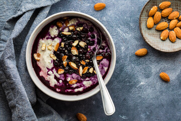 A greek yogurt super seed bowl topped with sauteed blueberries and almonds.