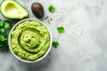 Healthy avocado spread with guacamole dip in a bowl on a white stone background featuring free text space - obrazy, fototapety, plakaty