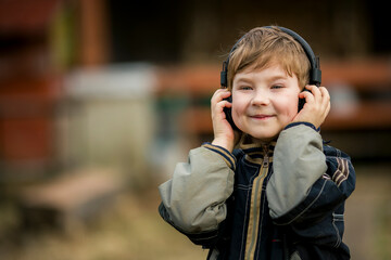 Portrait of a little country boy wearing headphones.