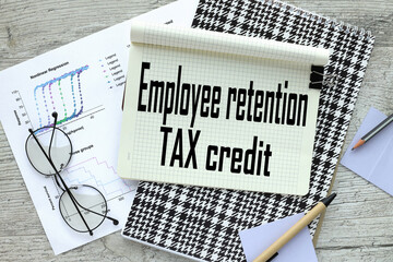 Employee retention tax credit notepad on a wooden table. text on page on financial chart