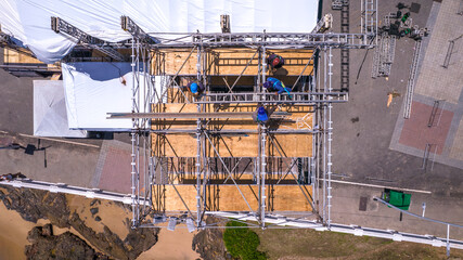 Workers assembling metal structure, Aerial top view