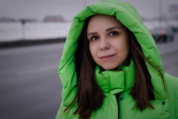 Woman in Green Coat Standing on Side of Road in winter