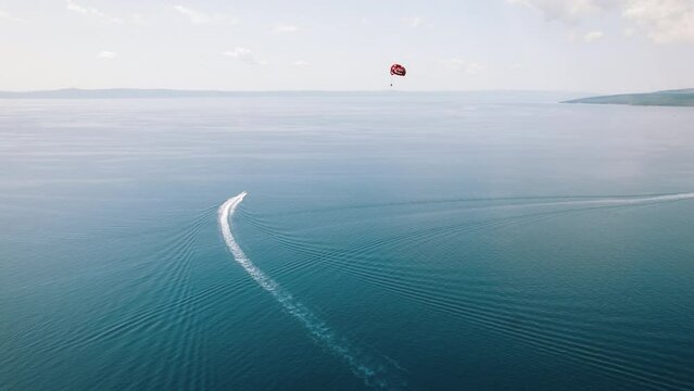 Parasailing Over Calm Adriatic Waters. The vastness of the sea provides a serene background for a parasailer in the sky.