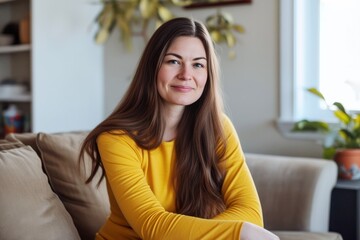 Obraz premium young caucasian woman sitting on couch in living room, portrait
