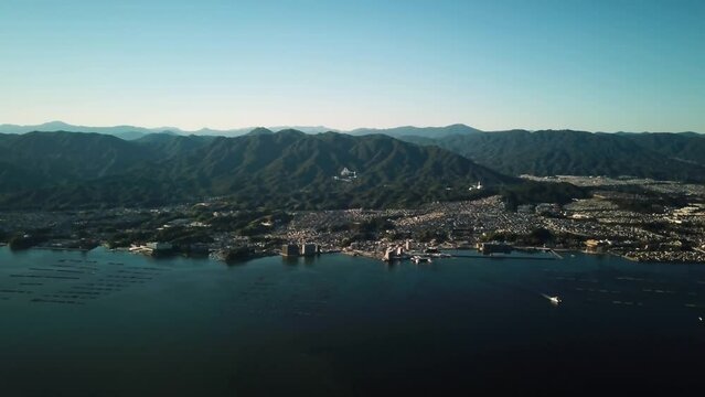 Miyajima Island near Hiroshima, Japan. Aerial view of an iconic Hiroshima torii gate in the sea and Itsukushima shrine. High quality 4k footage