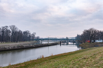 Metalowy most nad rzeką przy pochmurnym niebie