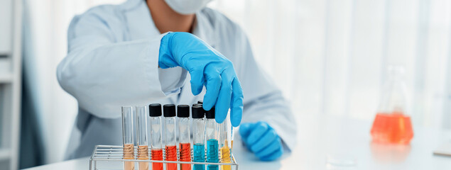 Laboratory researcher develop new medicine or cure using colorful chemical liquid in lab tube....