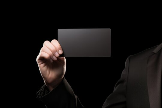A professional man in a formal tuxedo holding a business card. This image can be used to portray professionalism, networking, or business interactions