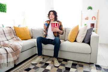 Full length photo of excited funny guy wear plaid shirt eating pop corn can coke watching...