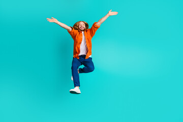 Full length photo of optimistic man dressed orange shirt flying hands up demonstrate big season sale isolated on teal color background