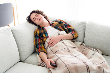 Photo of good mood cheerful guy wear plaid shirt watching tv sleeping couch indoors room home house