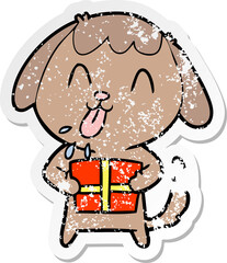 distressed sticker of a cute cartoon dog with christmas present