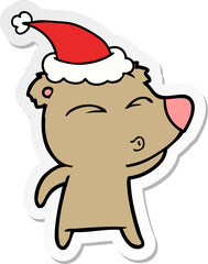 sticker cartoon of a whistling bear wearing santa hat