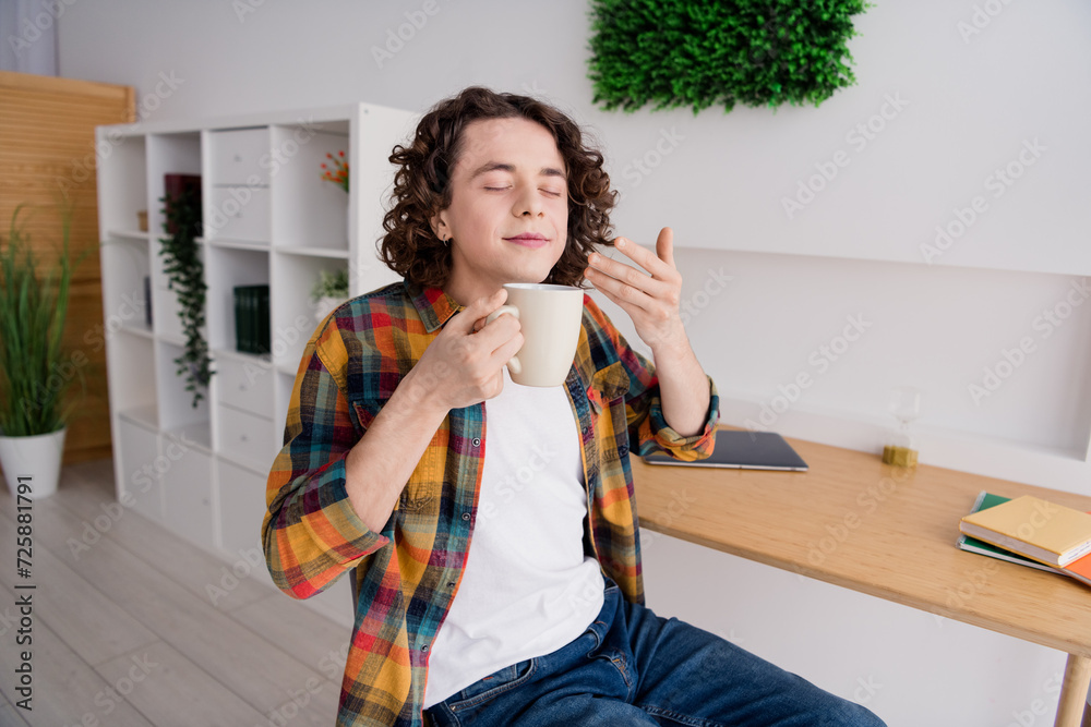 Poster Photo of cute funky guy wear plaid shirt closed eyes smelling tasty herbal tea aroma indoors room home house