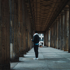 man at passage between columns in Berlin city